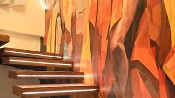 A staircase with wooden steps and a geometric mural in the background.