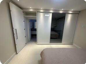 Ein Schlafzimmer mit einem Bett, einem Kleiderschrank und einem Spiegel.