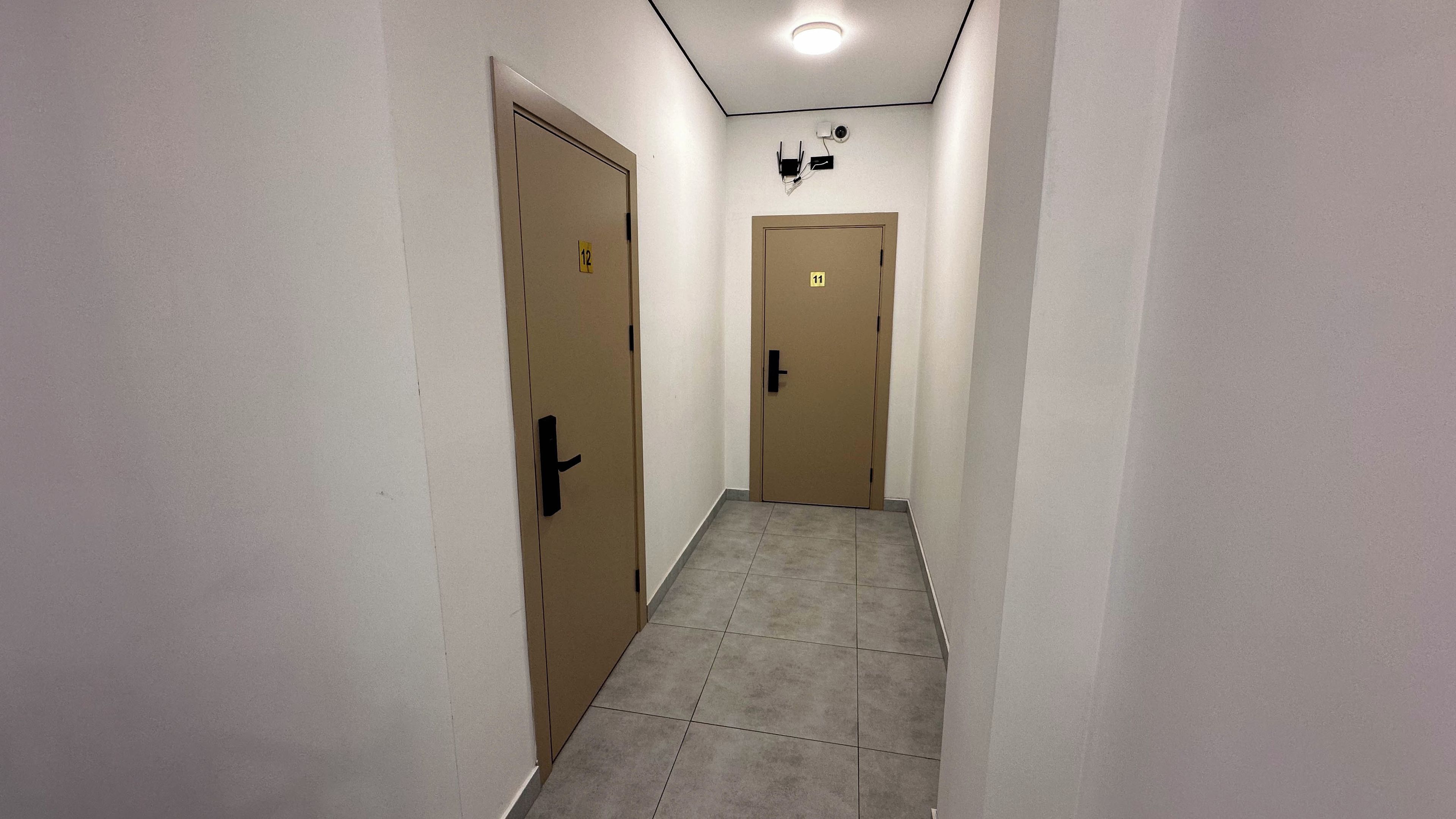 A narrow hallway with two doors, each marked with a number.