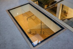 A modern room with a glass ceiling, wooden flooring, and a visible staircase. - Luxury6 Bed Villa-HotTub-FootballPitch-DogFriendly (Poole)