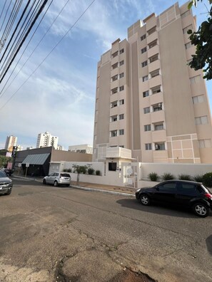 Un edificio de varios pisos con fachada plana, múltiples ventanales y una entrada portonada.