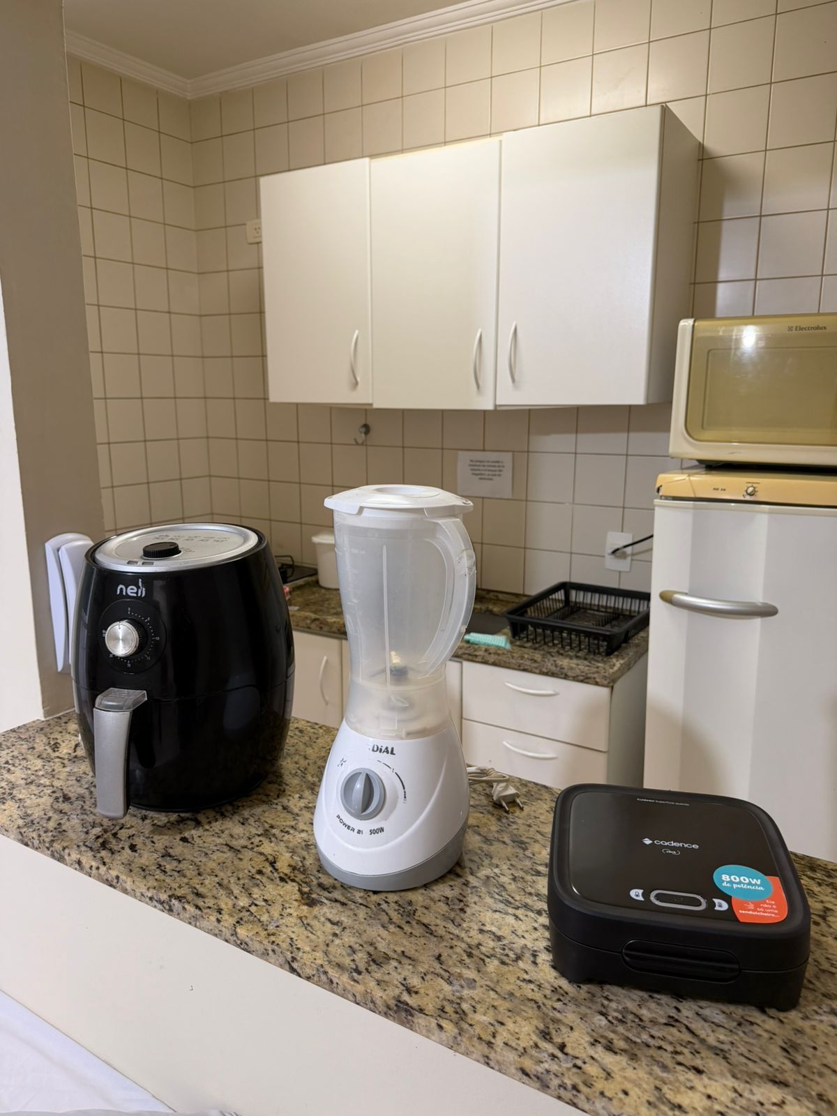 Eine Küche mit Kaffeemaschine, Mixer und einem mobilen Heizgerät auf der Arbeitsfläche.
