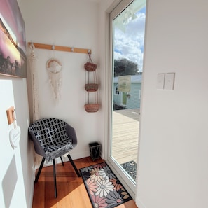 A room with a chair, a dreamcatcher, a hanging basket, and a view of the outside. - The Garden Nest – A Boulcott Retreat (Lower Hutt)