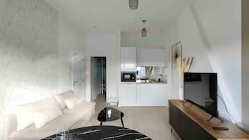 A modern living room with a dining table, sofa, and a kitchen in the background.