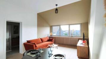 Een moderne woonruimte met een eettafel, een bank en een radiator.