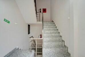 Una escalera con barandilla de metal y un letrero de salida de incendios en la pared.