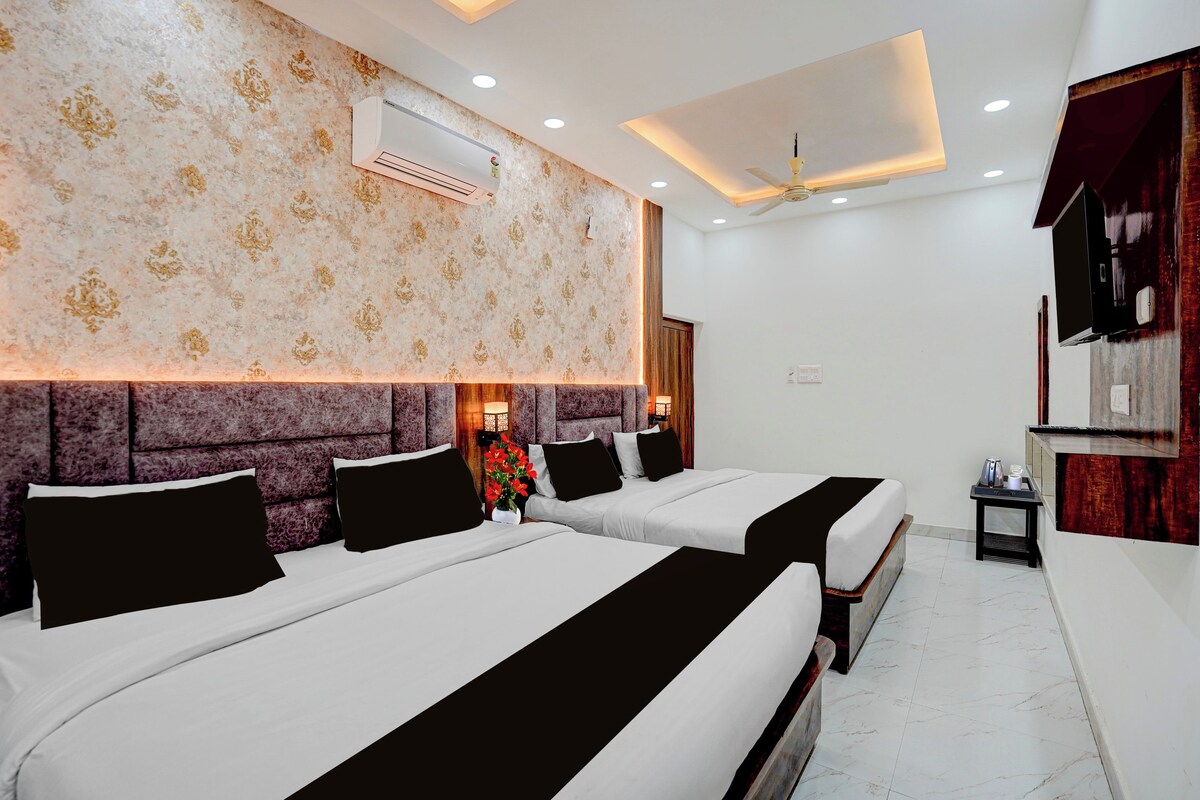 A hotel room with two beds, a ceiling fan, an air conditioning unit, and a decorative wall.