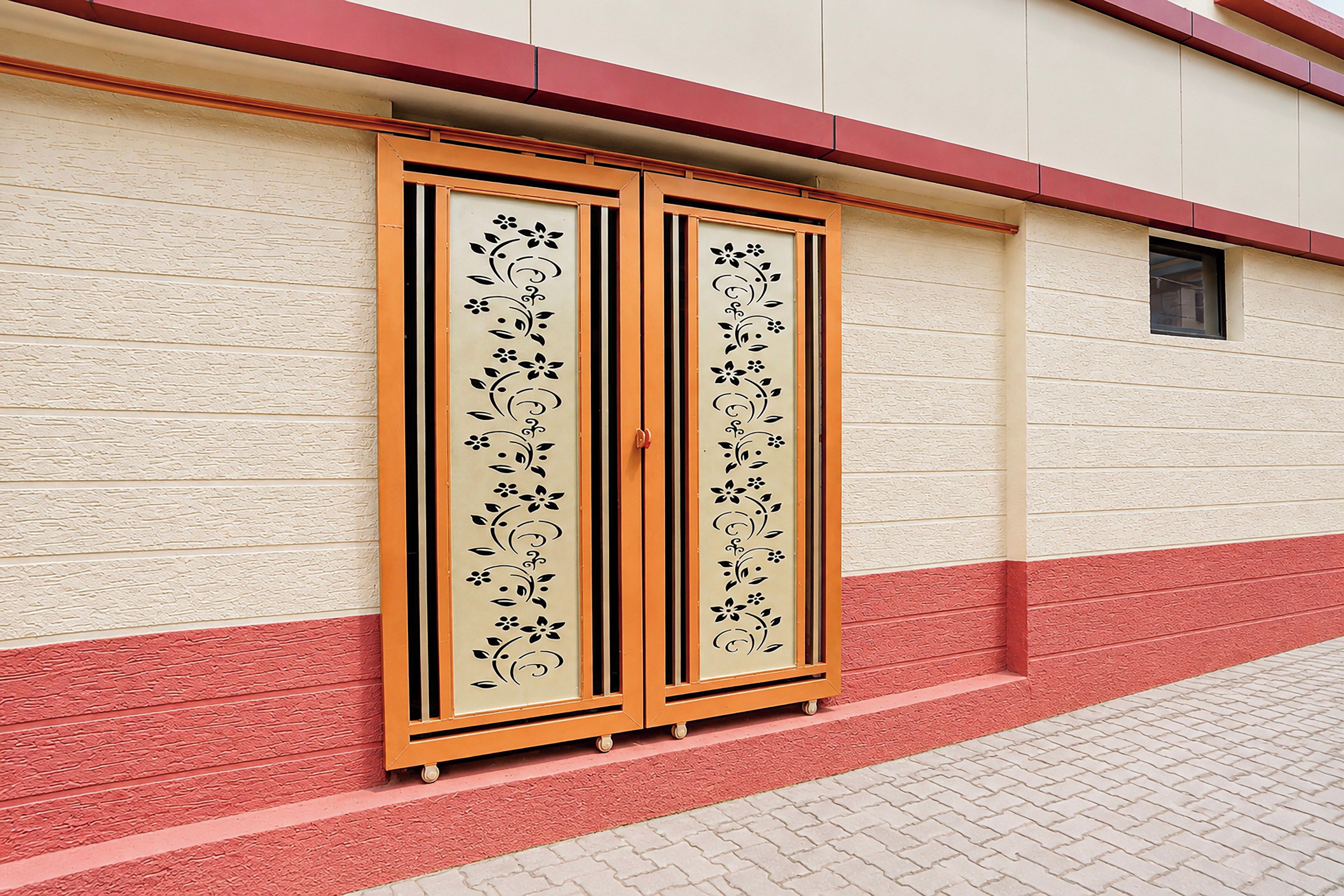 A building facade with a textured wall and a red and beige color scheme.