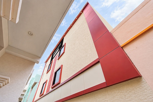 A multi-story building with a flat facade, large windows, and a visible sign indicating a business or service establishment. - Townhouse Oak Banaras Station (Varanasi)