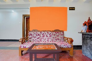 A reception area with a sofa, a small table, and a reception desk. - Townhouse Oak Banaras Station (Varanasi)