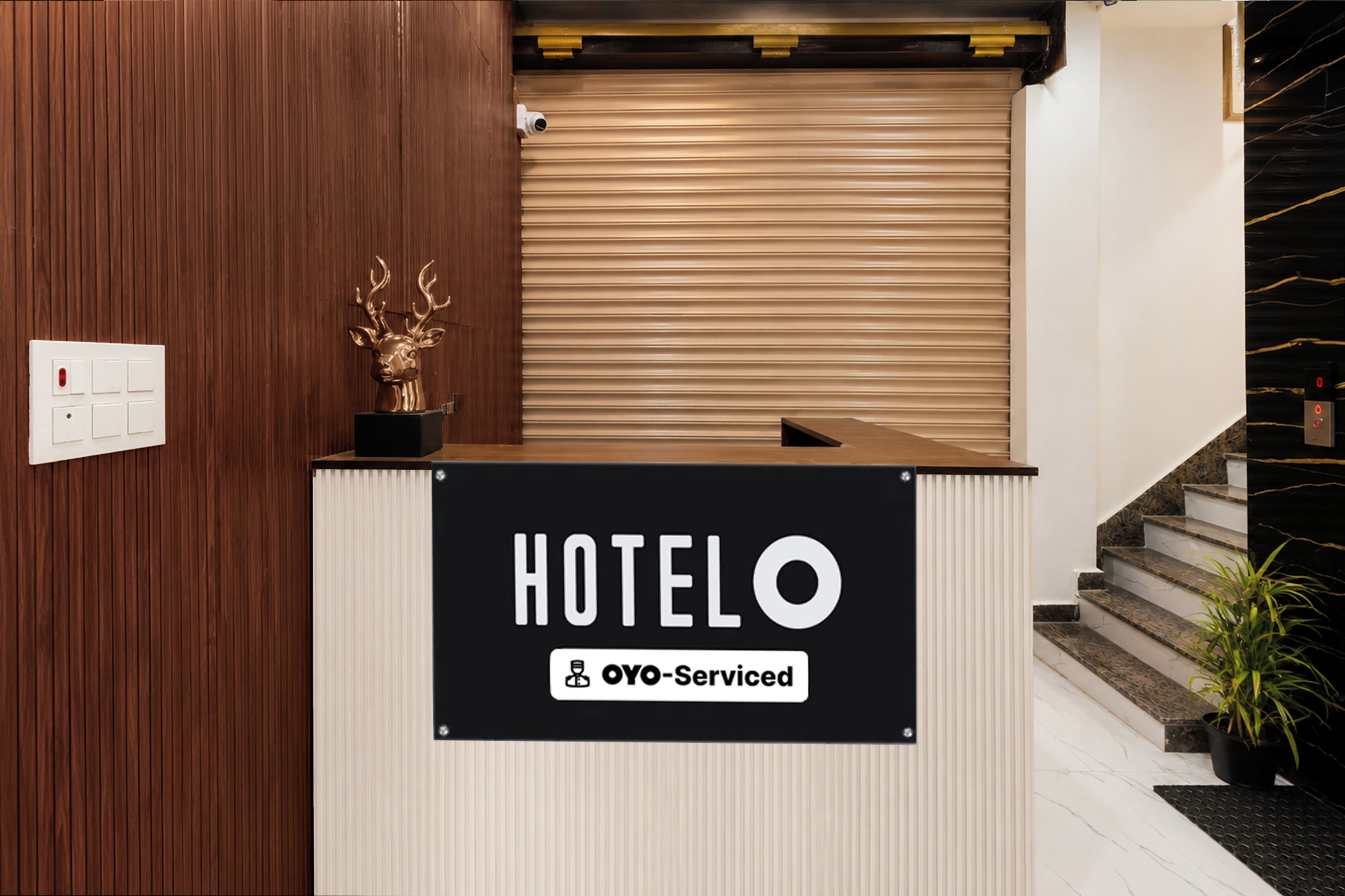A hotel reception desk with a sign indicating it is OYO-Serviced.