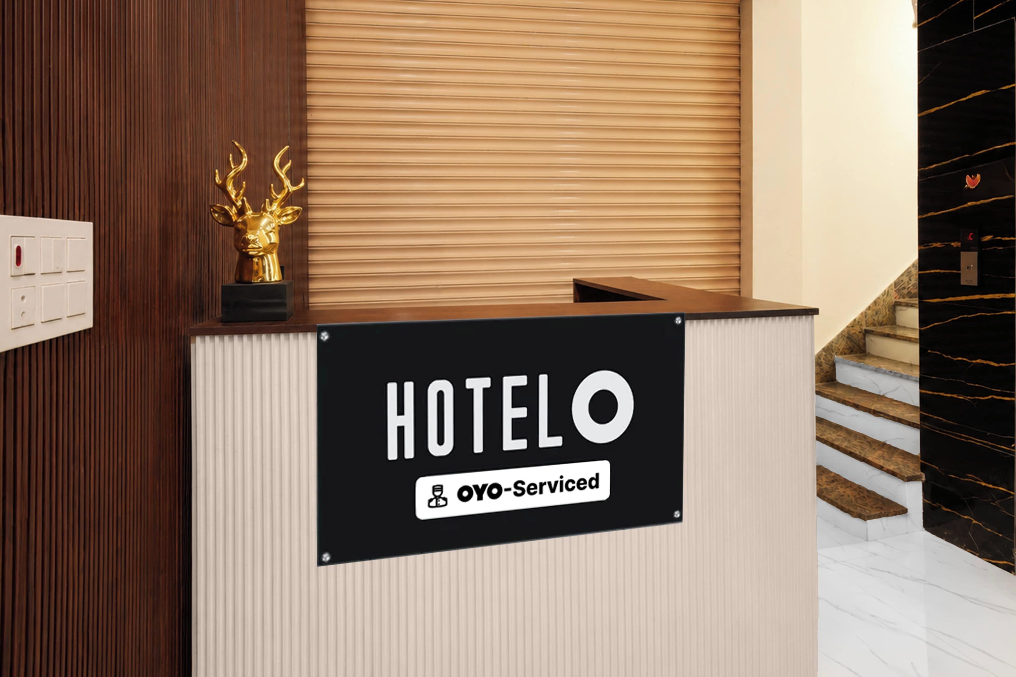 Un mostrador de recepción de hotel con un cartel que dice 'HOTELO' y 'OYO-Serviced'.