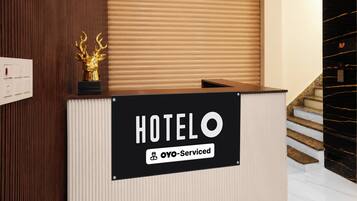 Un mostrador de recepción de hotel con un cartel que dice 'HOTELO' y 'OYO-Serviced'.