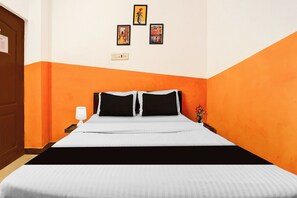 A hotel room with a bed, a nightstand, a lamp, and three framed pictures on the wall. - Hotel O Coimbatore International Airport (Coimbatore)