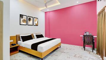 A modern bedroom with a bed, a nightstand, a desk, and a ceiling fan.