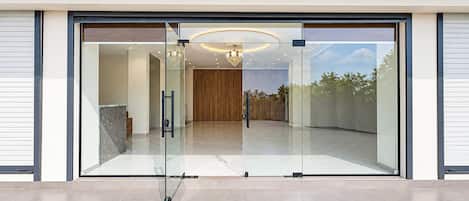 A modern entrance with a glass door, a reception desk, and a view of the interior.