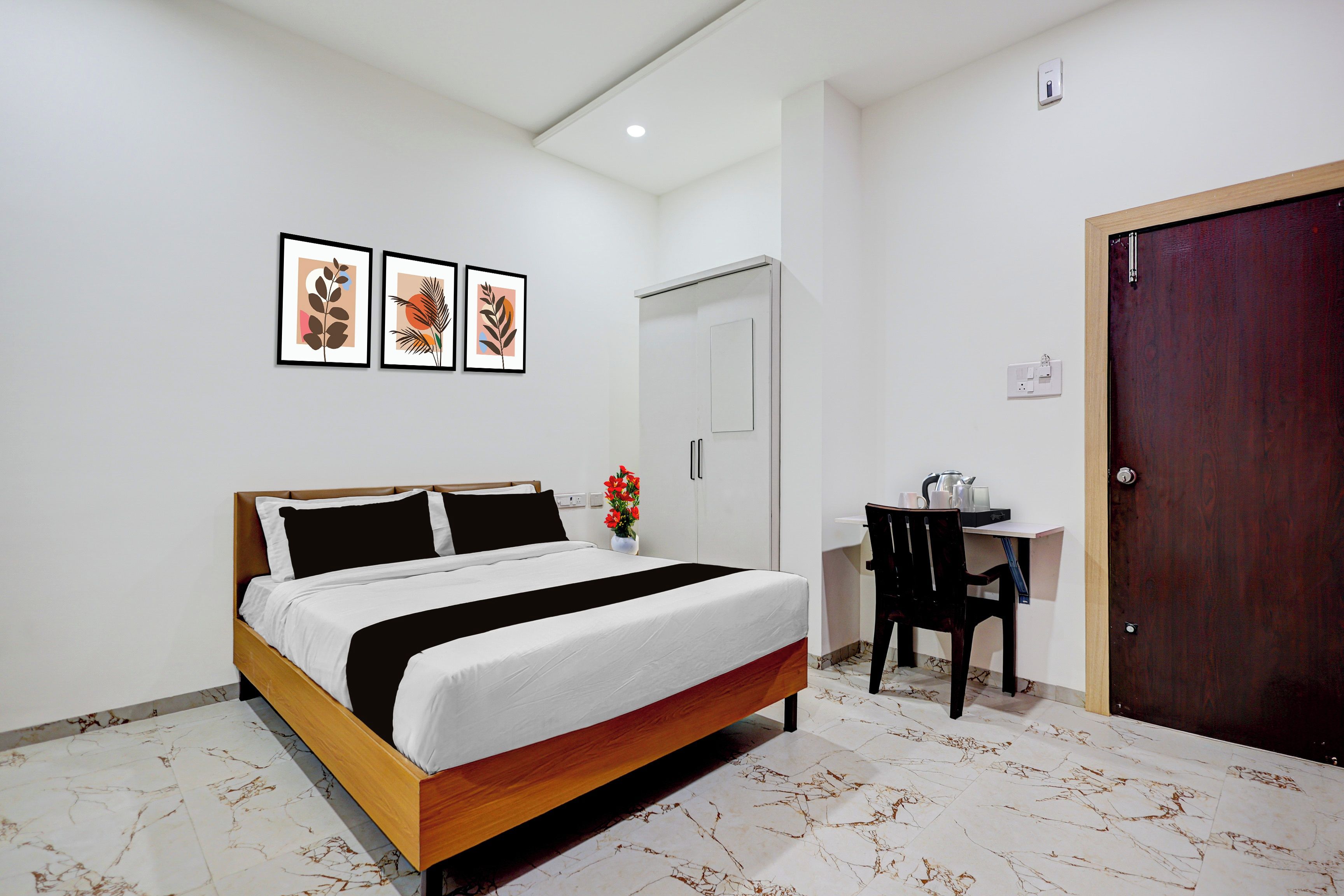 Un dormitorio con cama, escritorio y puerta.