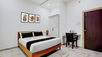 Un dormitorio con cama, escritorio y puerta.