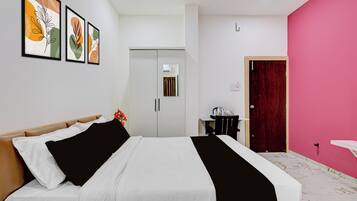 A hotel room with a bed, a desk, a chair, a wardrobe, and a door.