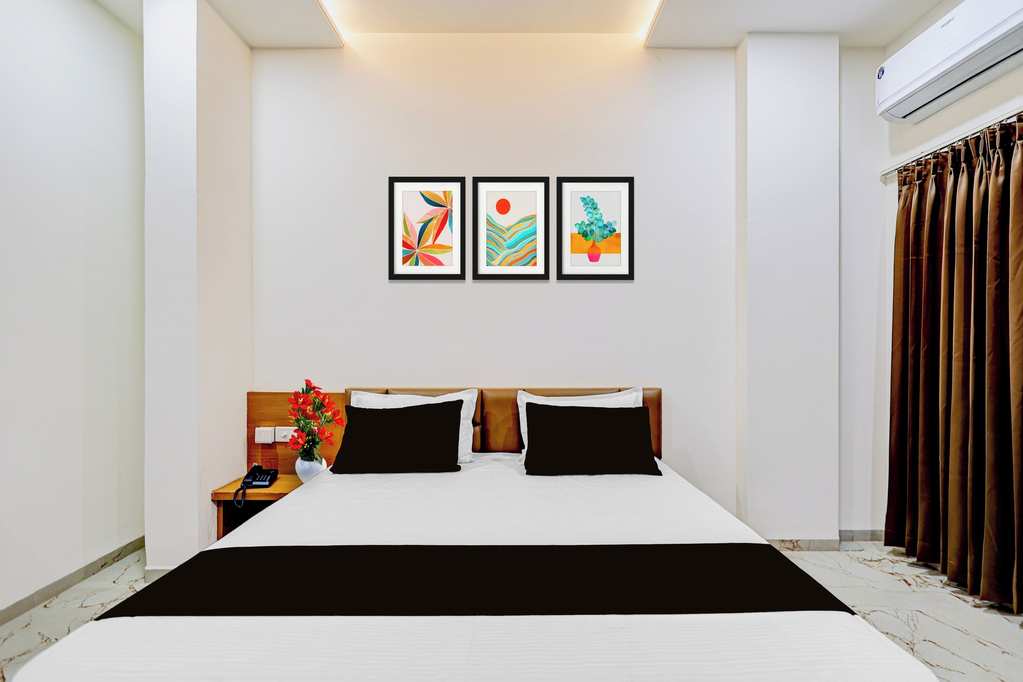 Une chambre d’hôtel équipée d’un lit, d’une table de chevet, d’un téléphone et d’un climatiseur fixé au mur.