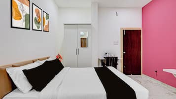 Een hotelkamer met een bed, een bureau, een stoel, een kledingkast en een deur.