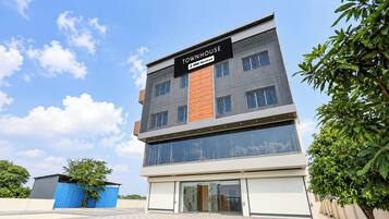 A modern multi-story building with a sign indicating it is serviced by Tovyo.
