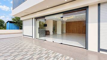 Een modern gebouw met een glazen ingang, een vloer met een patroon en uitzicht op het interieur.