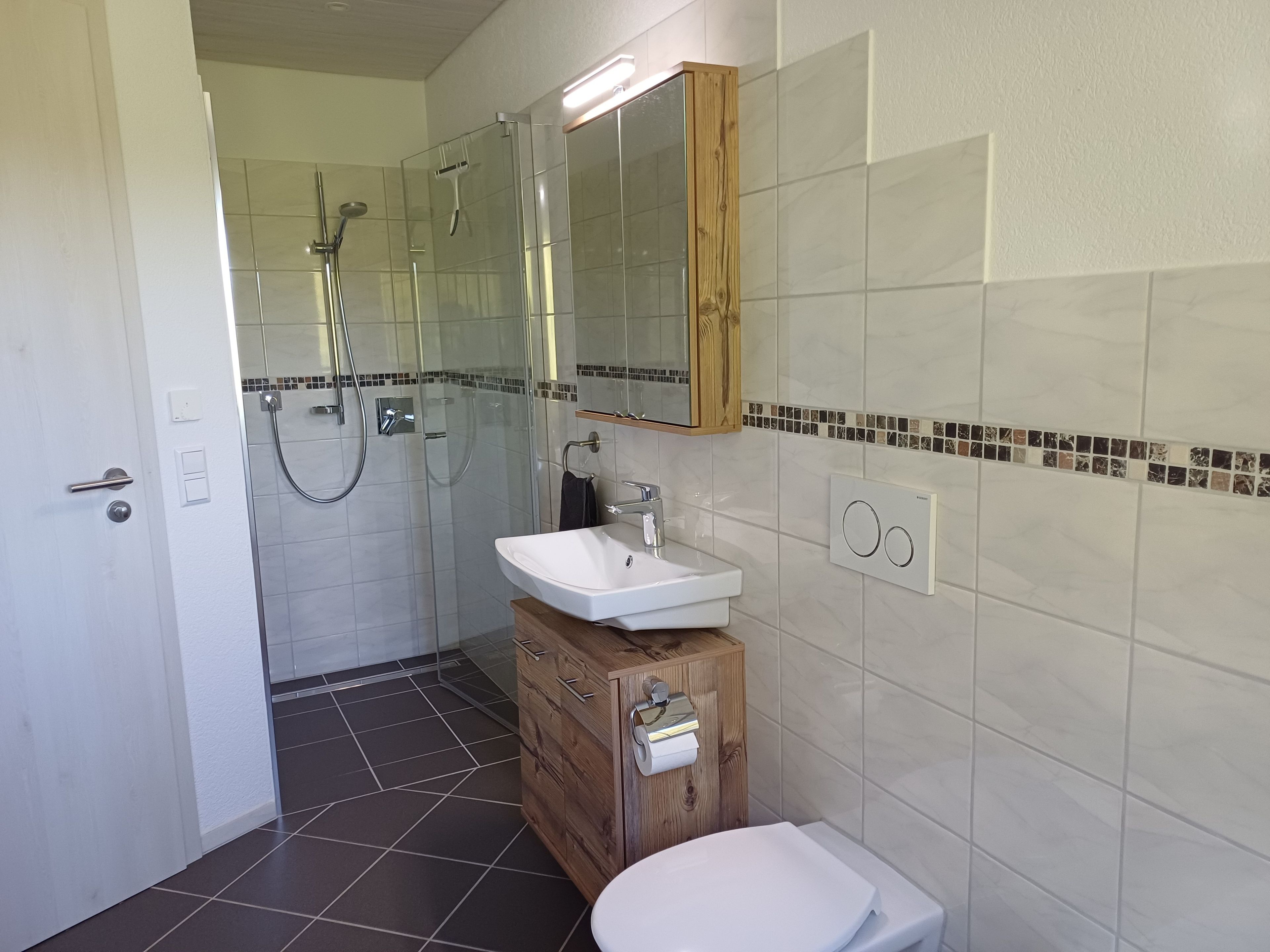 Ein Badezimmer mit Dusche, Waschbecken und Toilette.