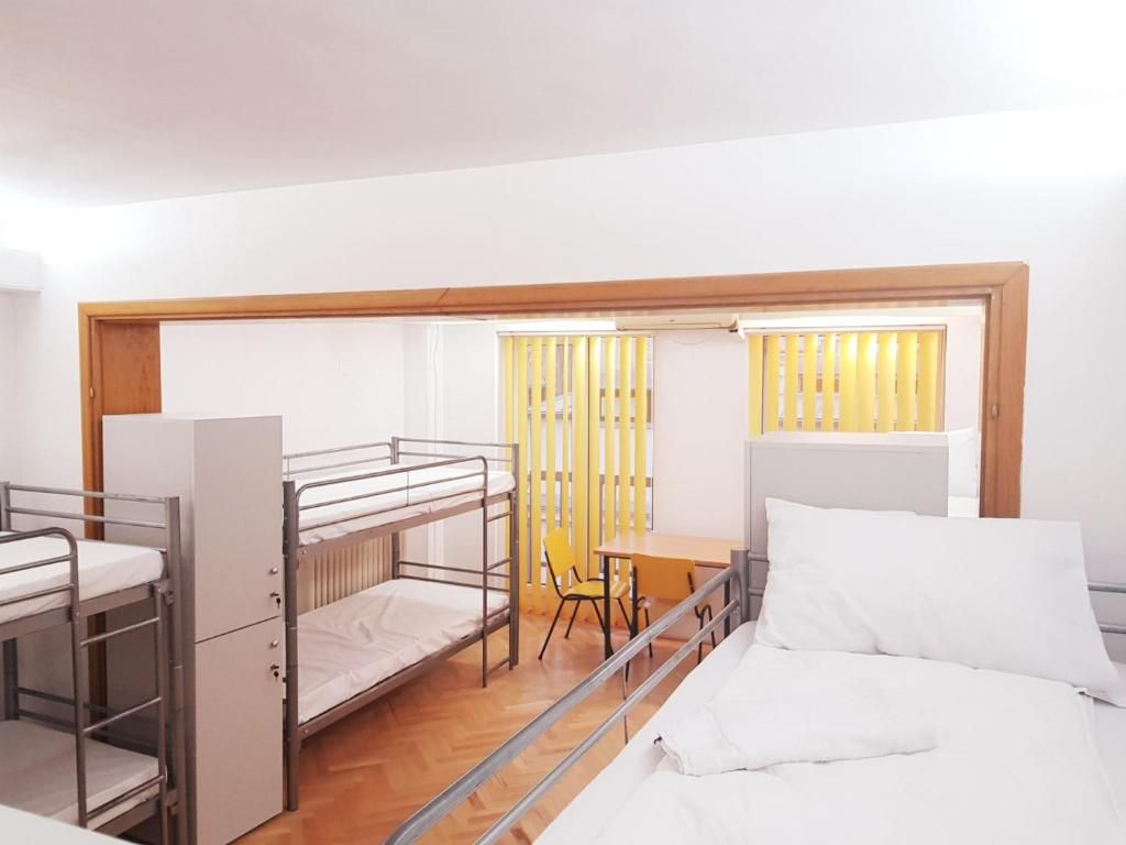 Un dormitorio con literas, un escritorio y una silla.