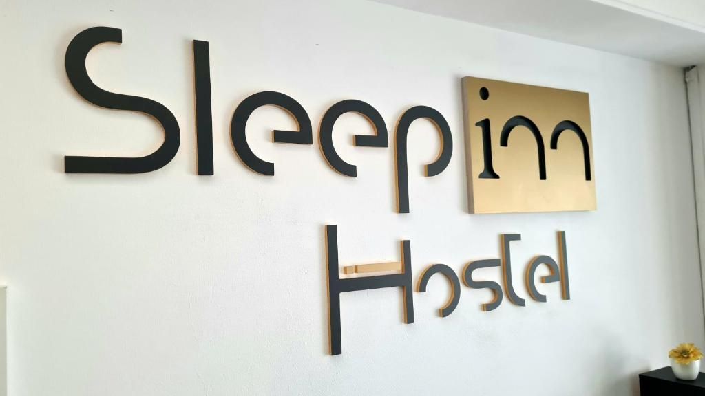 Una pared con el texto 'Sleepin Hostel', indicando el nombre del hostal.