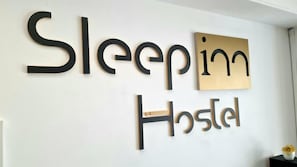 Una pared con el texto 'Sleepin Hostel', indicando el nombre del hostal.