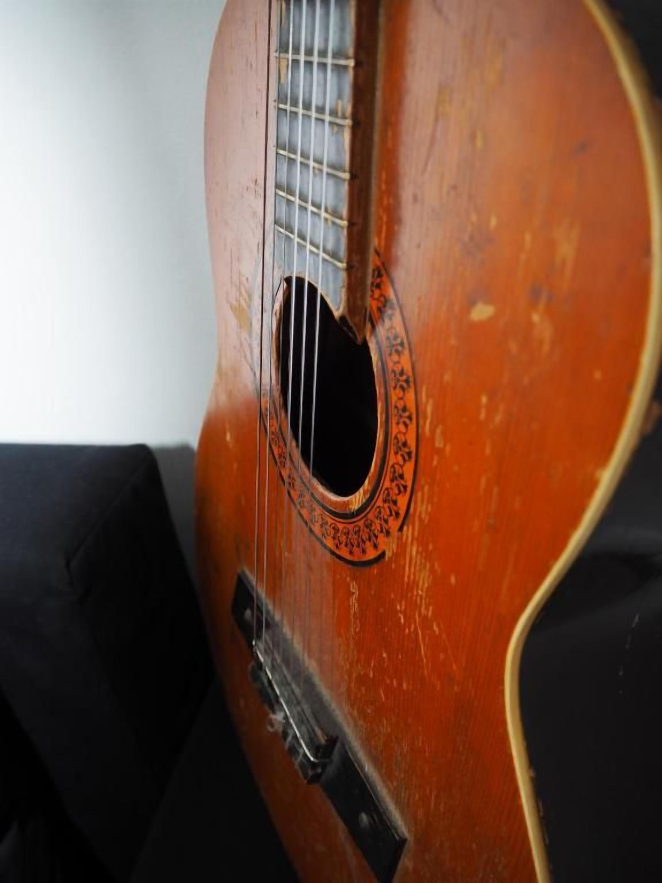 Primer plano de una guitarra con placa antipolvo y rosetón.