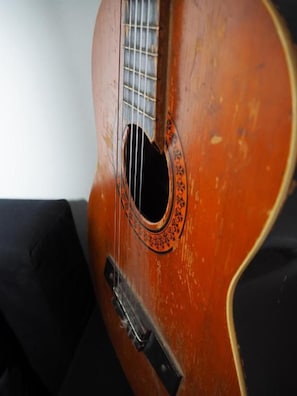 Primer plano de una guitarra con placa antipolvo y rosetón.