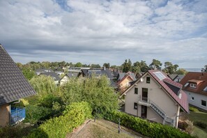 Ein Wohngebiet mit Häusern, Bäumen und einem bewölkten Himmel.