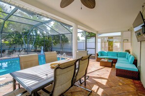 A covered outdoor area with a pool, seating, and a view of the surrounding greenery. - Family Oasis w/ Private Pool in Cape Coral! (Cape Coral)