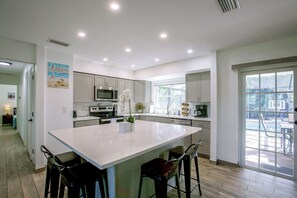 A modern kitchen with a large island, stainless steel appliances, and a view to the outside. - Family Oasis w/ Private Pool in Cape Coral! (Cape Coral)
