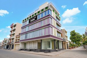 A multi-story building with a prominent sign indicating it is serviced by OYO.