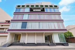 Un edificio de varios pisos con un letrero que dice 'TOWNHOUSE OAK' y 'OYO-Serviced'.
