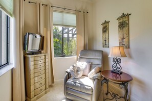 A room with a window, a sofa, a table with a lamp, and a television on a cabinet. - Lanai w/ Pool & Spa! Rotonda West Retreat (Rotonda West)