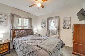 A bedroom with a bed, a nightstand, a dresser, and a ceiling fan. - Cozy, Convenient! Tulsa Stay Near Dtwn & Route 66 (Tulsa)