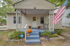 Ein Haus mit Veranda, einem Willkommensschild und einer großen Kürbis.