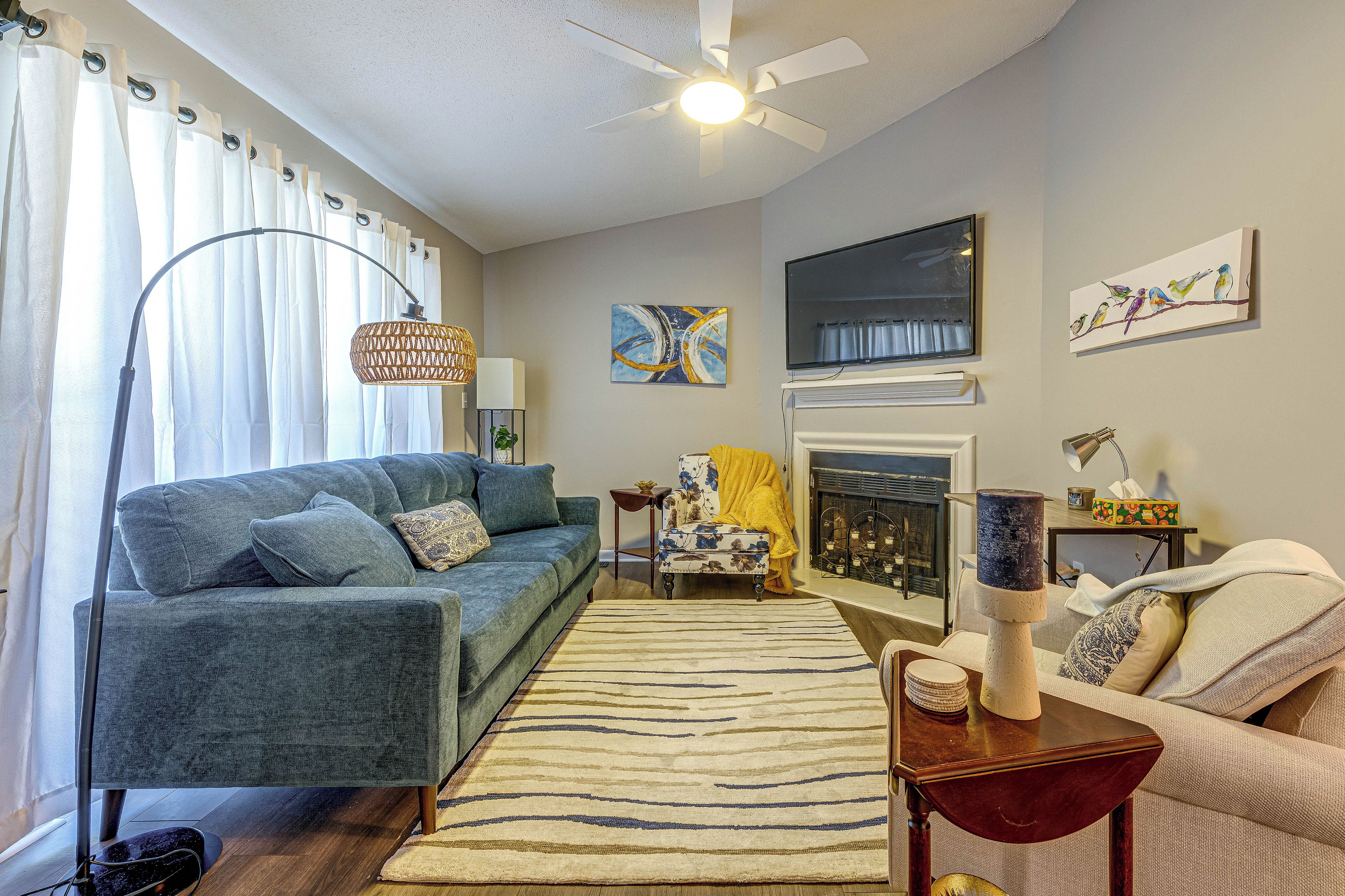 A living room with a sofa, a coffee table, a fireplace, and a television.