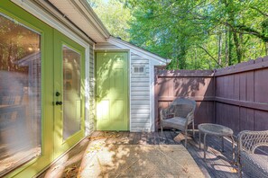 A house with a green door, a white door, and a small shed. There are wicker chairs and a table outside. - Raleigh Townhome w/ Deck: Near Shops & Dining (Raleigh)