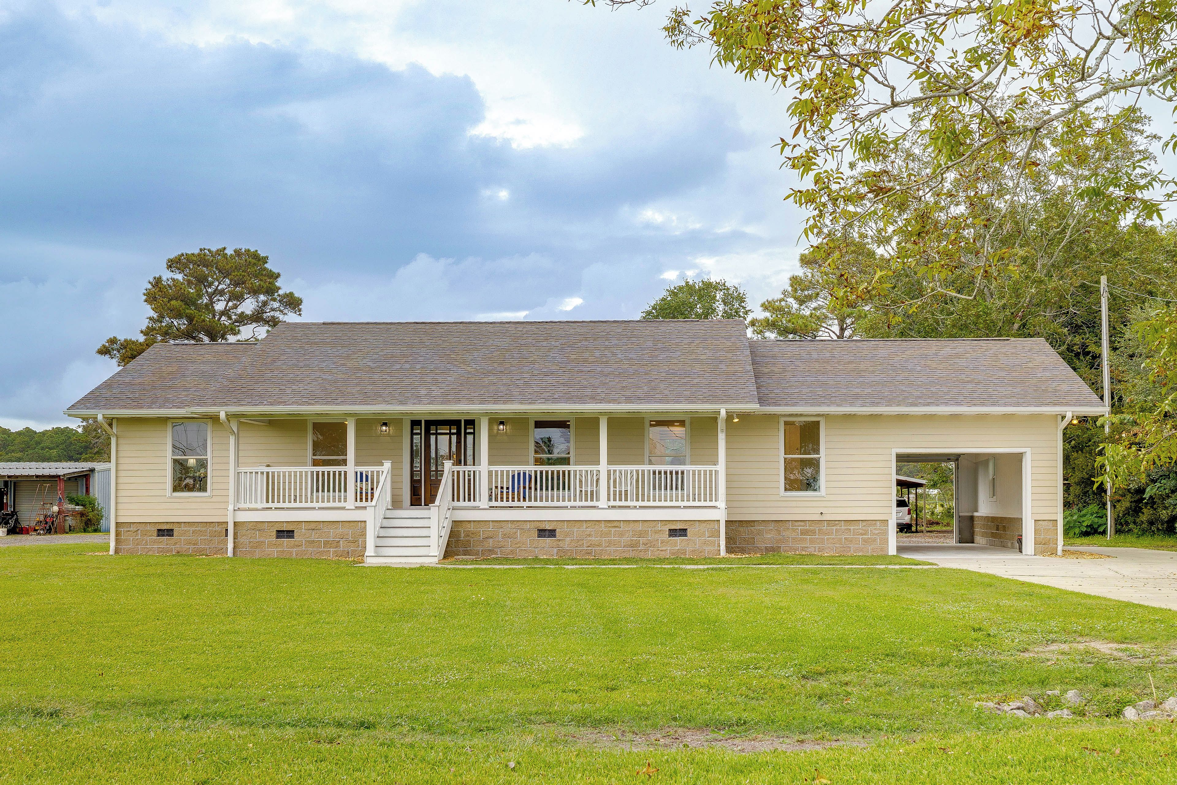 A two-story house with a porch, a garage, and a well-maintained lawn.
