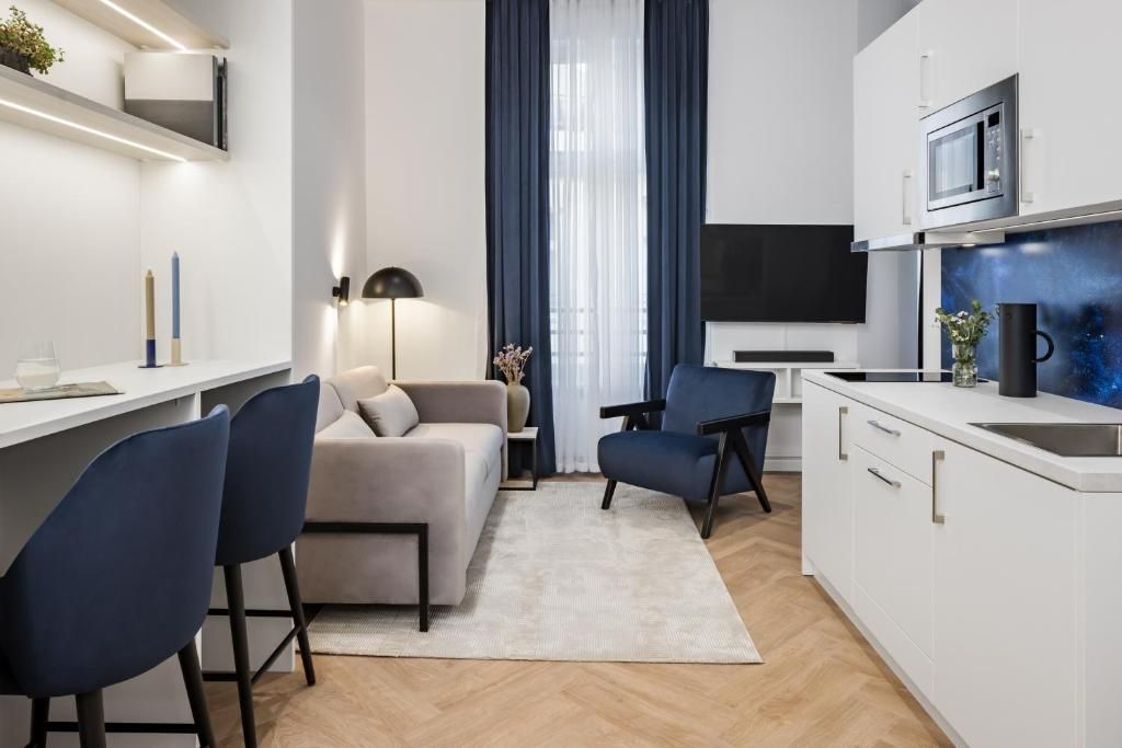 A modern kitchen with white cabinets, a microwave, and a coffee machine.