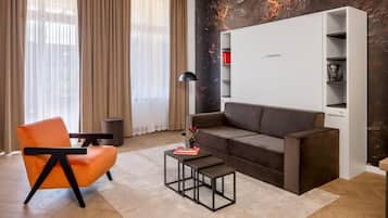 Una sala de estar moderna con un sofá, un sillón, una mesita de centro y una estantería.