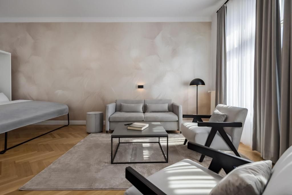 Una sala moderna con sofá, sillón y una mesita de centro.
