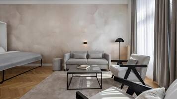 Una sala moderna con sofá, sillón y una mesita de centro.