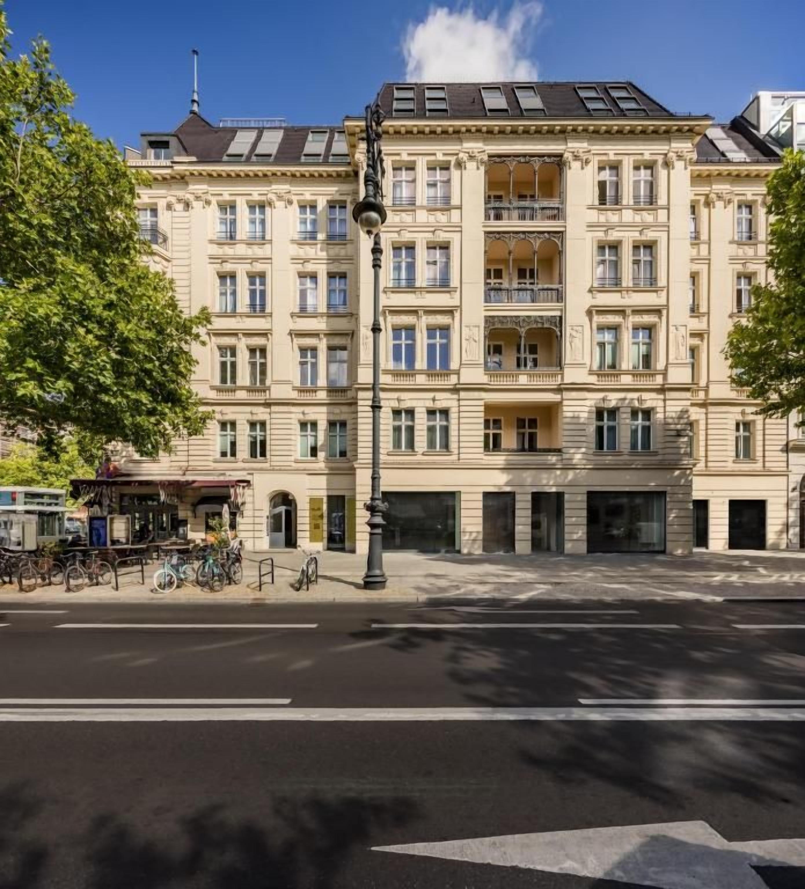 Un edificio de varios pisos con estilo arquitectónico clásico, que presenta balcones y grandes ventanales.