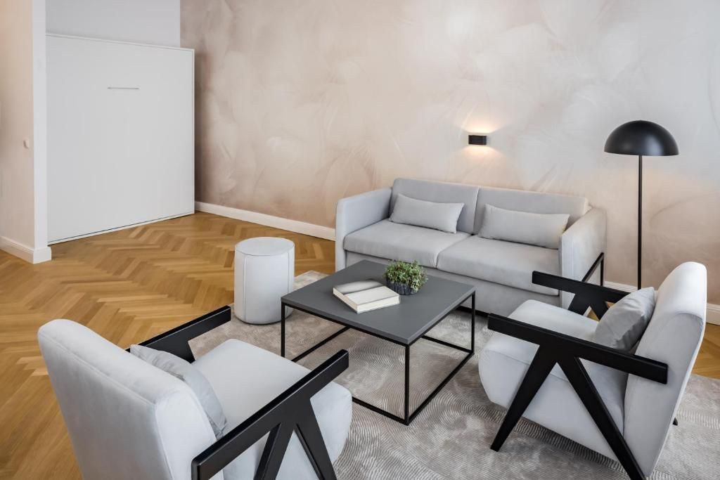Una sala de estar moderna con un sofá gris, una mesa de centro y una lámpara de pie.